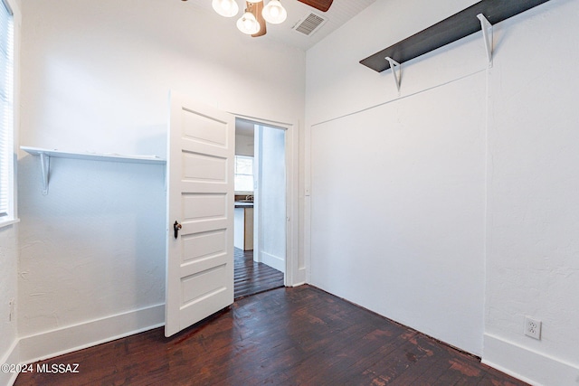 unfurnished room with dark wood-type flooring, visible vents, and ceiling fan