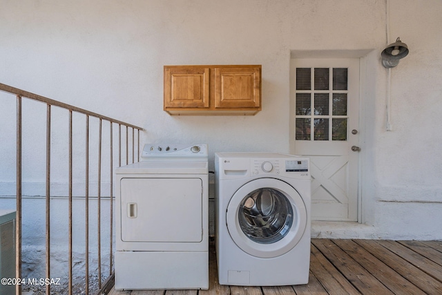 washroom with light wood-style flooring, cabinet space, and independent washer and dryer