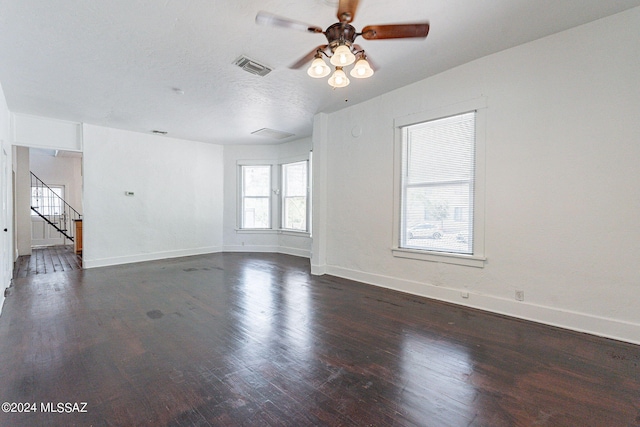 unfurnished living room with visible vents, baseboards, stairs, wood finished floors, and a textured ceiling