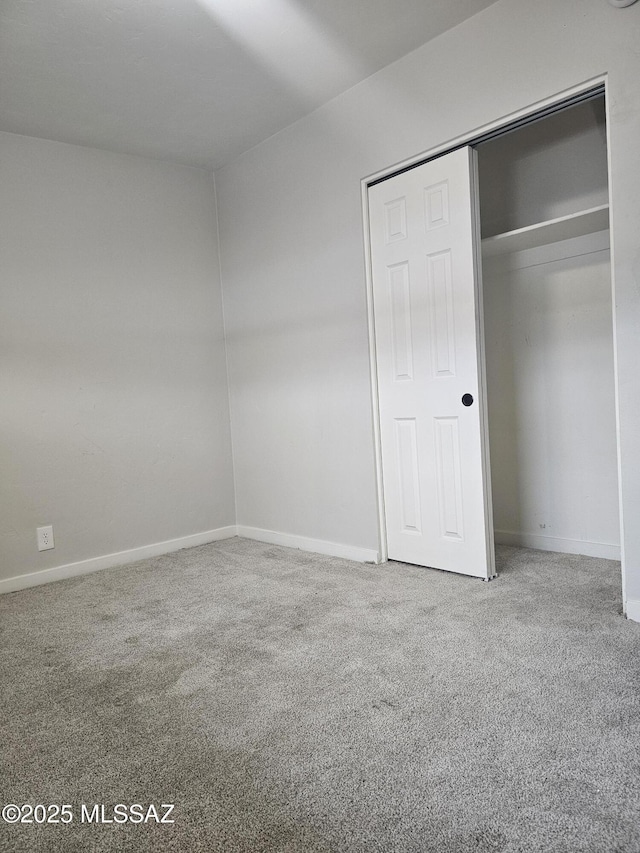 unfurnished bedroom with baseboards, a closet, and carpet floors