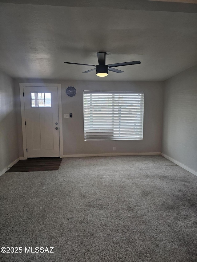 entrance foyer with baseboards, ceiling fan, and carpet flooring