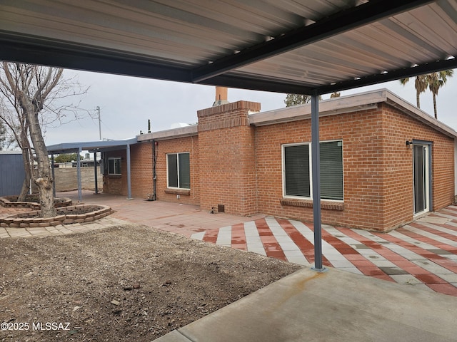 back of house featuring a patio area and brick siding