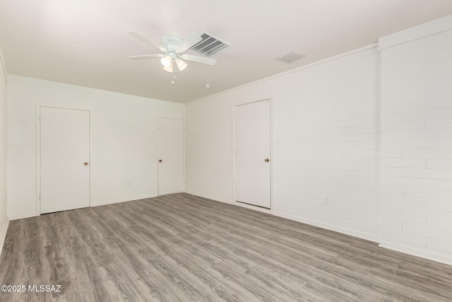 unfurnished bedroom featuring wood finished floors, visible vents, and ceiling fan