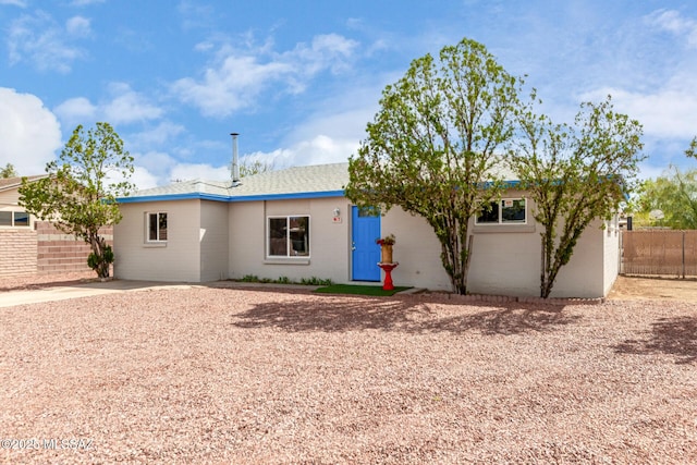 ranch-style home featuring fence
