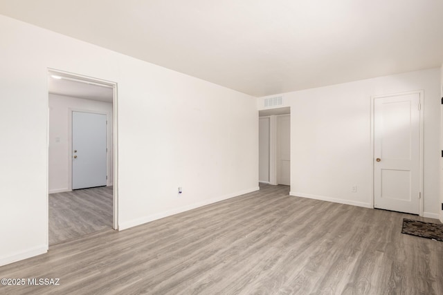 interior space with visible vents, light wood-type flooring, and baseboards