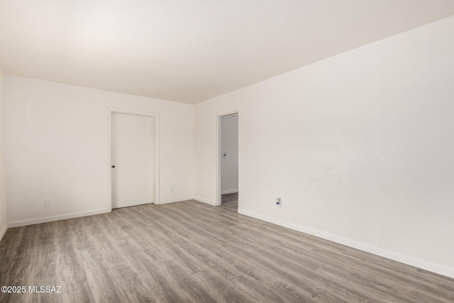 unfurnished room featuring baseboards and wood finished floors
