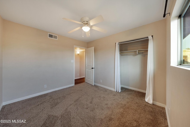 unfurnished bedroom featuring carpet, a closet, baseboards, and a ceiling fan