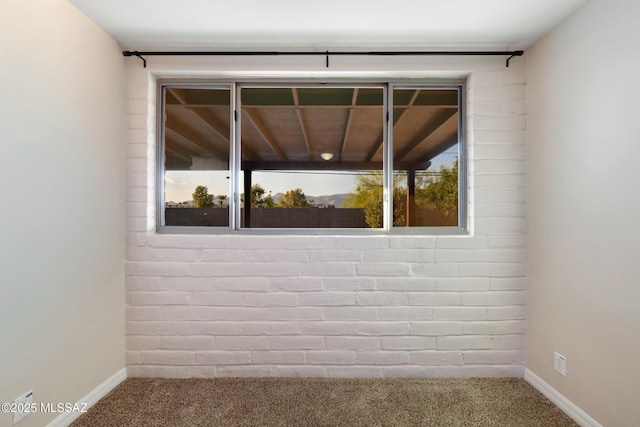 carpeted empty room featuring baseboards