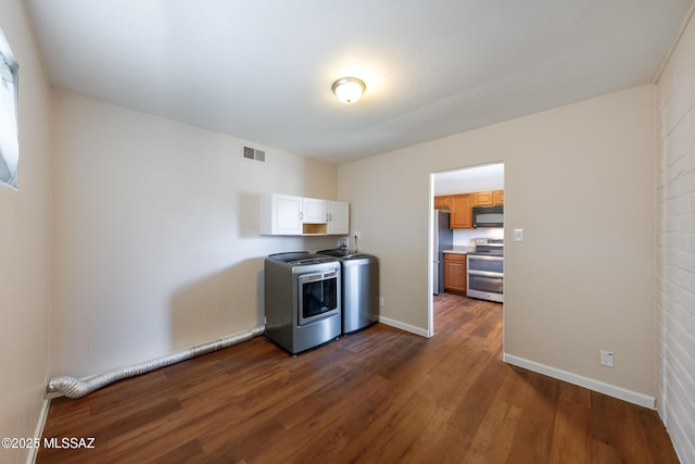 kitchen featuring stainless steel appliances, separate washer and dryer, dark wood-style floors, light countertops, and baseboards