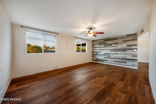 unfurnished room featuring ceiling fan and dark wood-type flooring