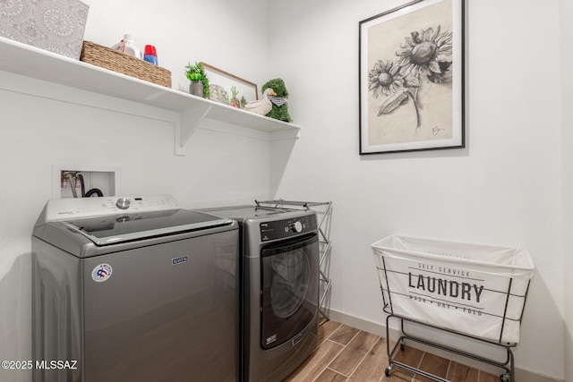 laundry room featuring laundry area, wood finish floors, baseboards, and washing machine and clothes dryer