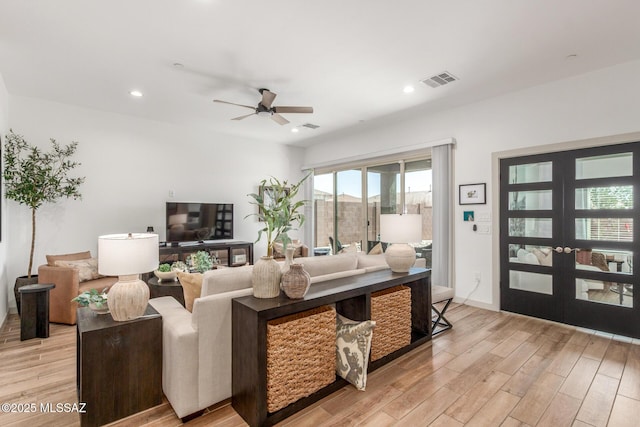 living area with recessed lighting, visible vents, light wood-style floors, and a ceiling fan