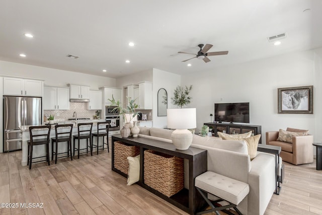 living area featuring recessed lighting, visible vents, ceiling fan, and light wood finished floors