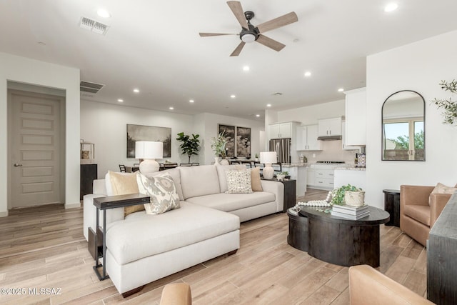 living area featuring visible vents, recessed lighting, light wood-style floors, and a ceiling fan