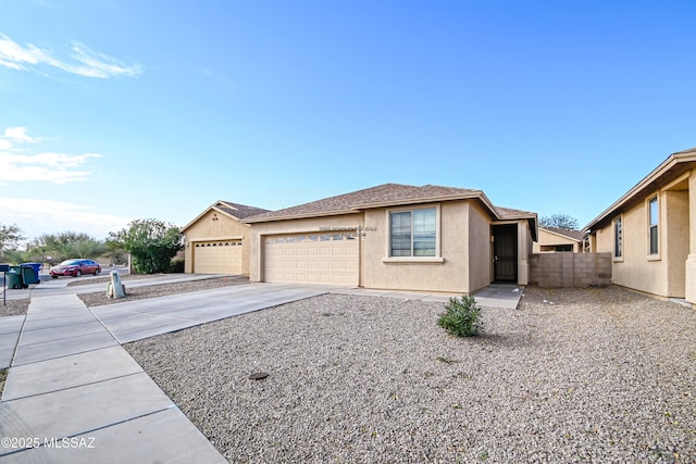 ranch-style home featuring fence, concrete driveway, roof with shingles, stucco siding, and a garage