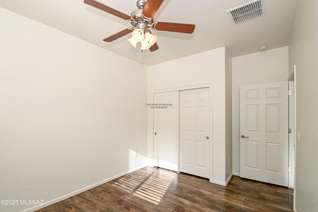 unfurnished bedroom featuring visible vents, baseboards, wood finished floors, a closet, and a ceiling fan