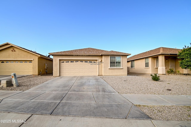 view of front of house featuring concrete driveway, an attached garage, and stucco siding