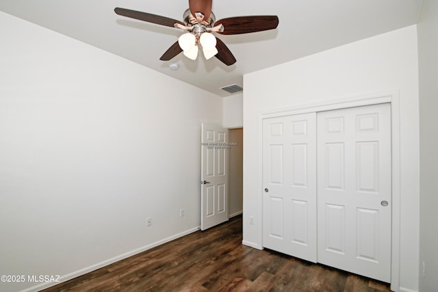 unfurnished bedroom with visible vents, dark wood-type flooring, ceiling fan, baseboards, and a closet