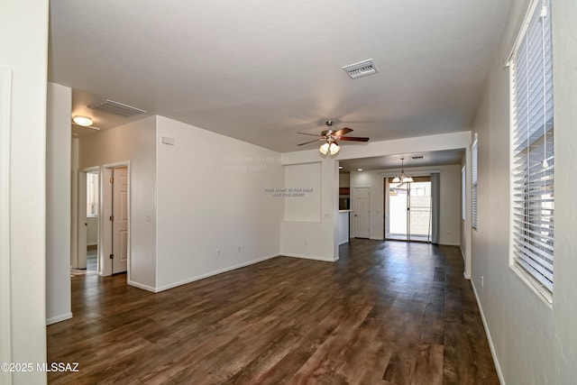 unfurnished living room featuring dark wood-style floors, visible vents, baseboards, and a ceiling fan