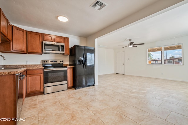 kitchen featuring visible vents, ceiling fan, a sink, appliances with stainless steel finishes, and brown cabinets