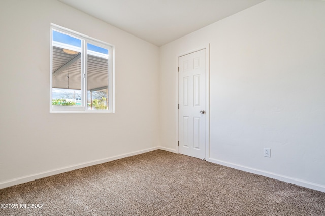 carpeted spare room featuring baseboards