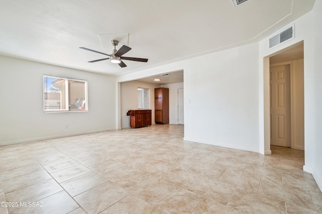 empty room with a ceiling fan, visible vents, and baseboards