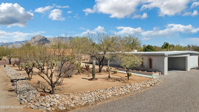 view of front facade featuring a mountain view, brick siding, and an attached garage