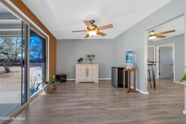 unfurnished room with ceiling fan, baseboards, a healthy amount of sunlight, and wood finished floors