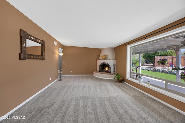 unfurnished living room with carpet flooring, a fireplace, and baseboards