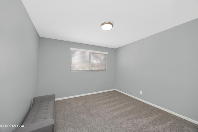 carpeted empty room featuring baseboards