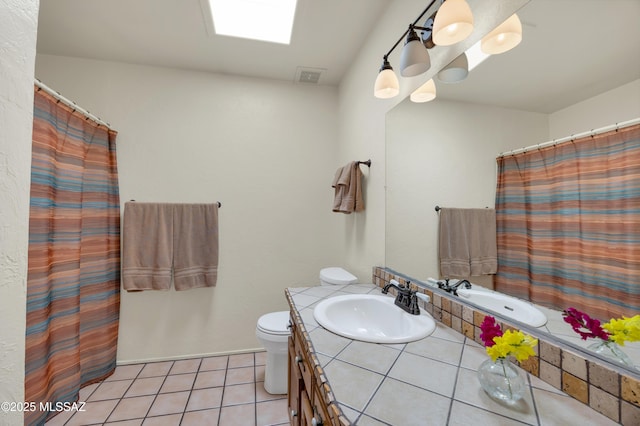 full bath with visible vents, toilet, a skylight, tile patterned floors, and vanity