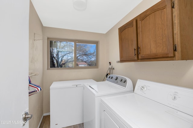 washroom with cabinet space and separate washer and dryer