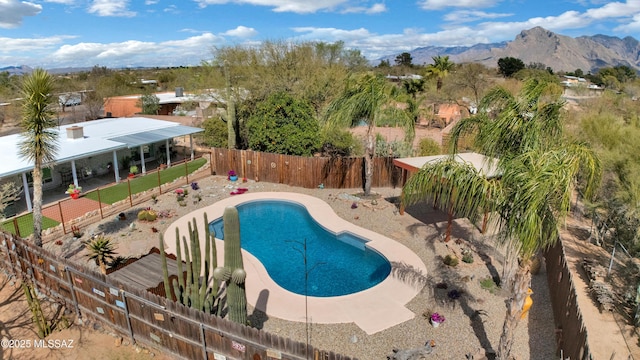 view of swimming pool with a fenced in pool, a fenced backyard, a mountain view, and a patio area