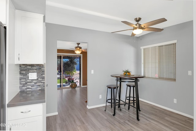 dining area featuring a ceiling fan, wood finished floors, and baseboards