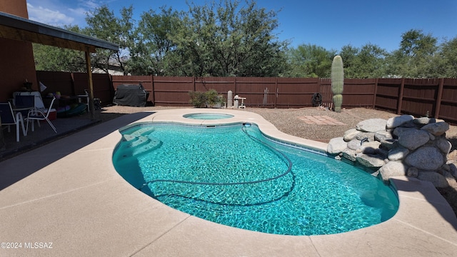 view of pool featuring an in ground hot tub, a fenced backyard, a fenced in pool, and a patio area