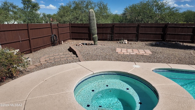 view of pool with a fenced in pool, an in ground hot tub, and a fenced backyard