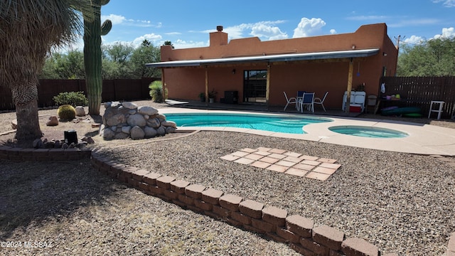 view of pool with a patio, a fenced in pool, a fenced backyard, and an in ground hot tub