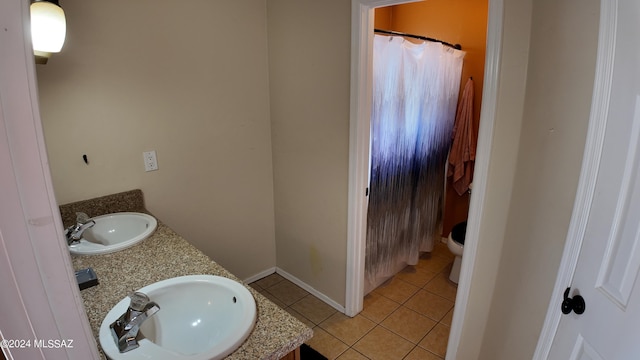 full bathroom with tile patterned flooring, double vanity, toilet, and a sink