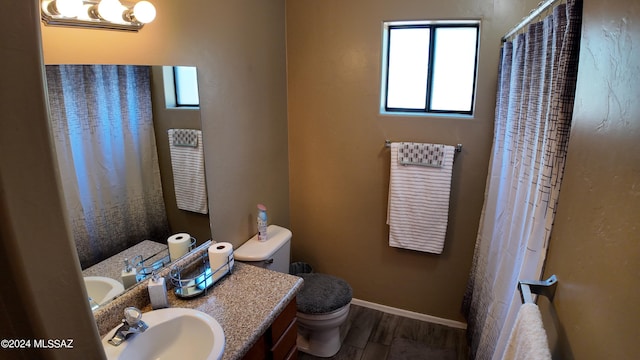 full bathroom with baseboards, toilet, a shower with shower curtain, wood finished floors, and vanity