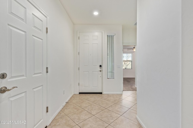 foyer featuring light tile patterned floors, baseboards, and ceiling fan