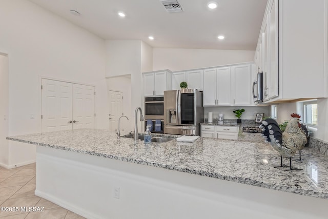 kitchen featuring visible vents, appliances with stainless steel finishes, light stone countertops, and a sink