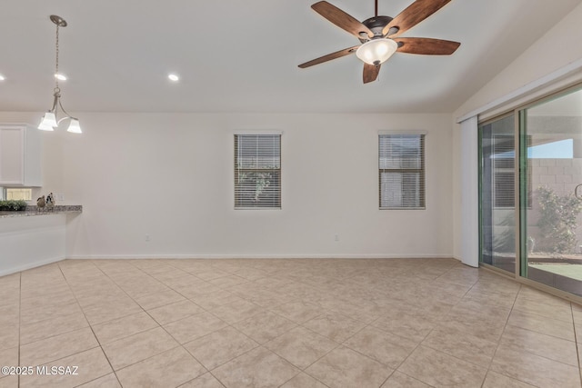 spare room with plenty of natural light, baseboards, light tile patterned floors, and ceiling fan