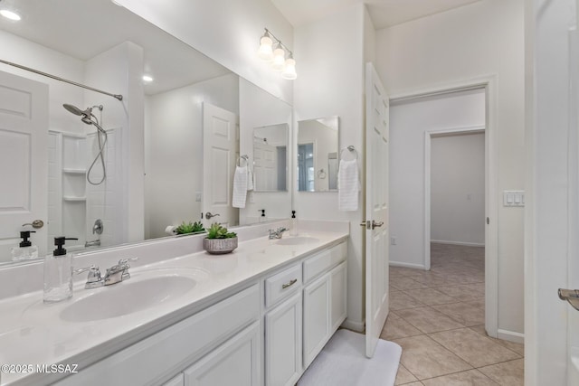 full bath with tile patterned floors, double vanity, a shower, and a sink