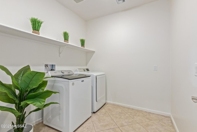 laundry area featuring light tile patterned floors, laundry area, baseboards, and separate washer and dryer