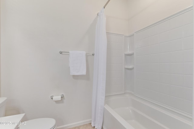 full bath with tile patterned floors, shower / bath combination with curtain, toilet, and baseboards