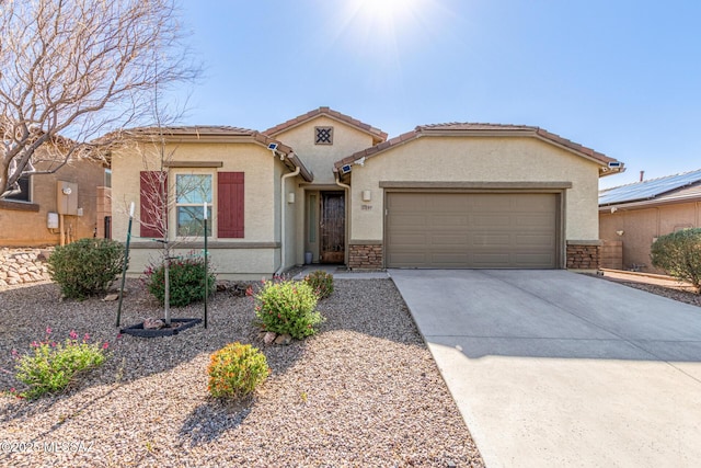 view of front facade with a garage, driveway, and stucco siding