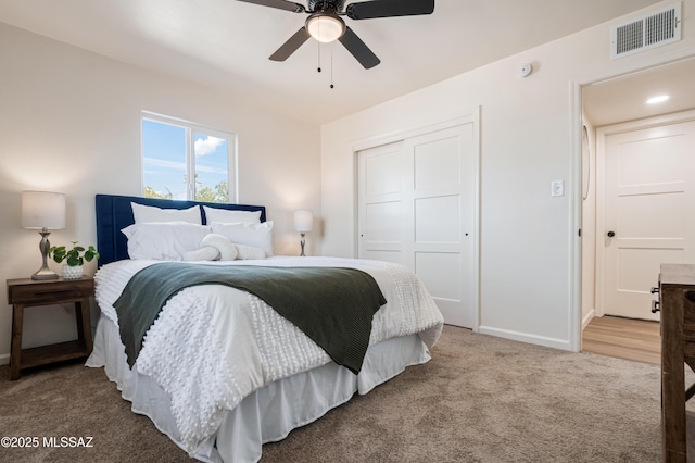 carpeted bedroom featuring visible vents, baseboards, a closet, and a ceiling fan