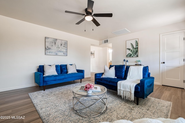 living area with visible vents, baseboards, wood finished floors, and a ceiling fan