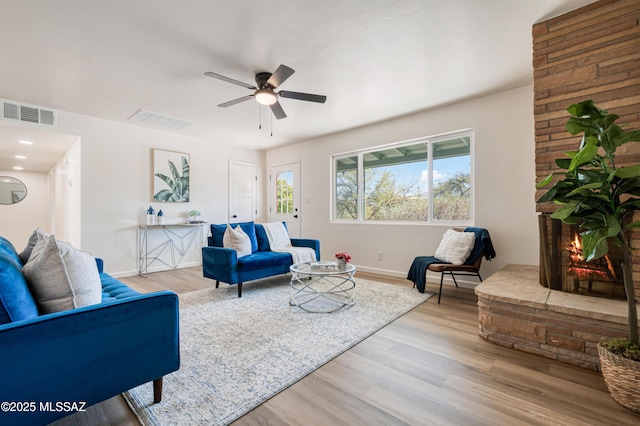 living area featuring a ceiling fan, light wood-style floors, and visible vents