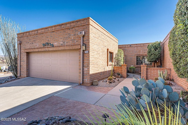 view of home's exterior with a gate, fence, a garage, and driveway